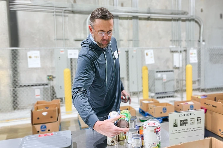 A man volunteering time at a local food bank.